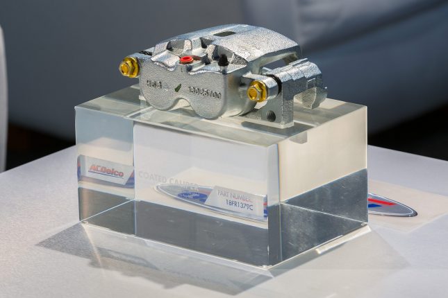 An ACDelco Caliper 18FR1379C on display atop a clear, acrylic block.