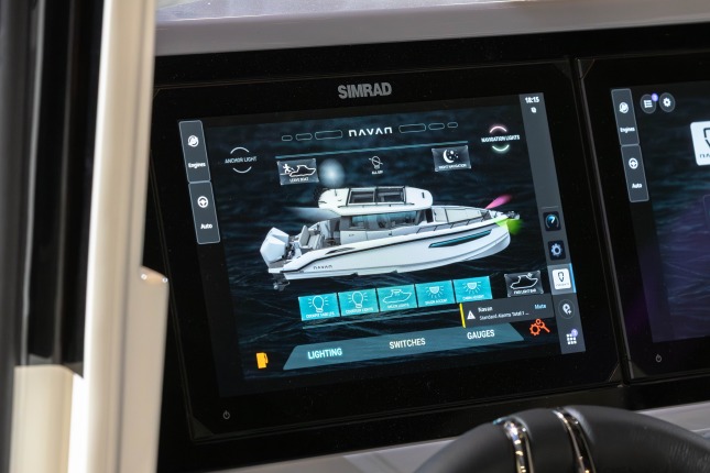 A closeup of a SIMRAD screen on a Navan boat at the Brunswick Exhibit at CES 2026. A white boat on a dark screen with various lighting controls and other features are prominient on the screen.